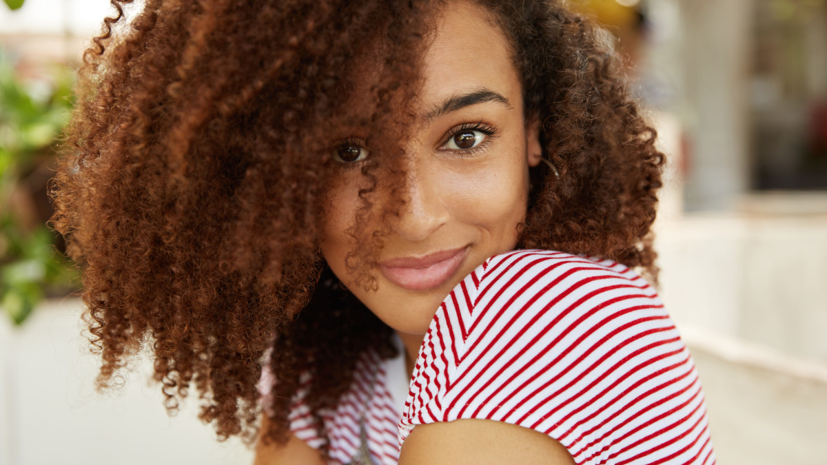 gros plan sur une jeune femme aux cheveux bouclés